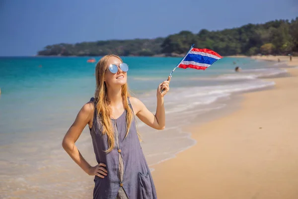 Ο ιός του κερατοειδούς τελείωσε. Η καραντίνα αποδυναμώθηκε. Βγάλε τη μάσκα. Τώρα μπορείς να ταξιδέψεις. Ευτυχισμένη γυναίκα που διασκεδάζει στην παραλία με τη σημαία της Ταϊλάνδης. Όμορφο κορίτσι απολαμβάνει τα ταξίδια στην Ασία — Φωτογραφία Αρχείου