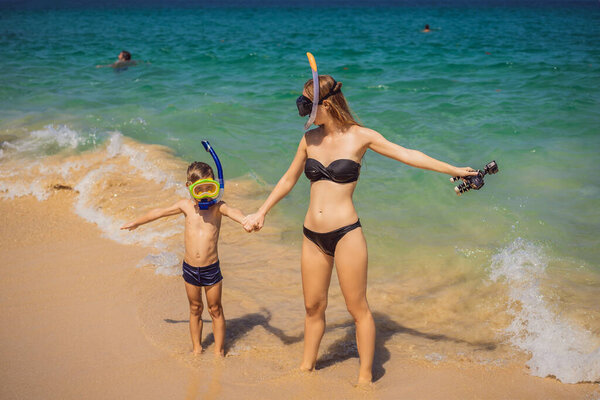 Coronavirus is over. Quarantine weakened. Take off the mask. Now you can swim. happy mother and son snorkeling on beach