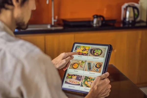 man orders food for lunch online using Tablet