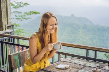 Coronavirus bitti. Karantina zayıfladı. Maskeni çıkar. Artık halka açık yerlere gidebilirsin. Genç bayan dağdaki bir kafede kahve içiyor.