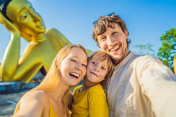 Il Coronavirus e 'finito. La quarantena si e 'indebolita. Togliti la maschera. Ora puoi viaggiare. Buon turista madre, padre e figlio sullo sfondo della statua di Buddha sdraiato — Foto Stock