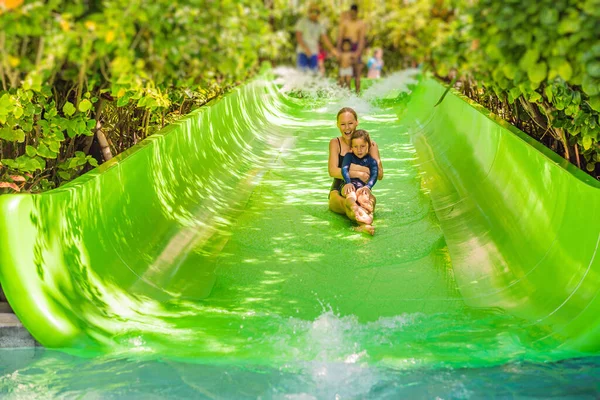 O Coronavírus acabou. Quarentena enfraquecida. Tira a máscara. Agora você pode ir a lugares públicos. Mãe e filho se divertir no parque aquático — Fotografia de Stock