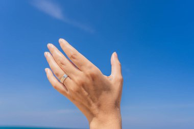 Coronavirus bitti. Karantina zayıfladı. Maskeni çıkar. Artık seyahat edebilirsin. Yüzüğü çizilmiş bir kadın eli havada uçan bir uçağı tutuyor. Uçak konseptiyle seyahat etmek. Metin