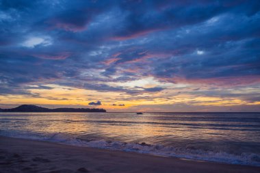Coronavirus bitti. Karantina zayıfladı. Maskeni çıkar. Artık halka açık yerlere gidebilirsin. Güzel sarı ve mavi gün batımı Denizin ve kumsalın üzerinde