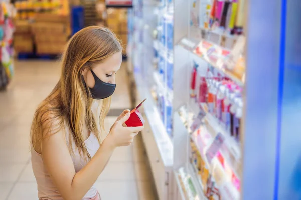Тревожная женщина носит медицинскую маску против коронавируса при покупке бытовой химии в супермаркете или магазине - здоровье, безопасность и пандемия концепции - молодая женщина в защитной маске и — стоковое фото