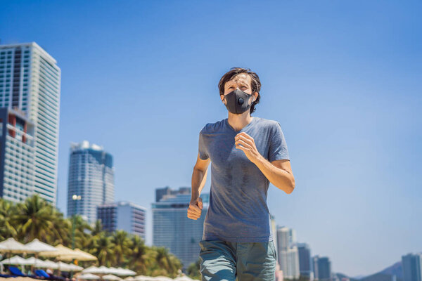 Man runner wearing medical mask. Runningin in the city against the backdrop of the city. Coronavirus pandemic Covid-19. Sport, Active life in quarantine surgical sterilizing face mask protection