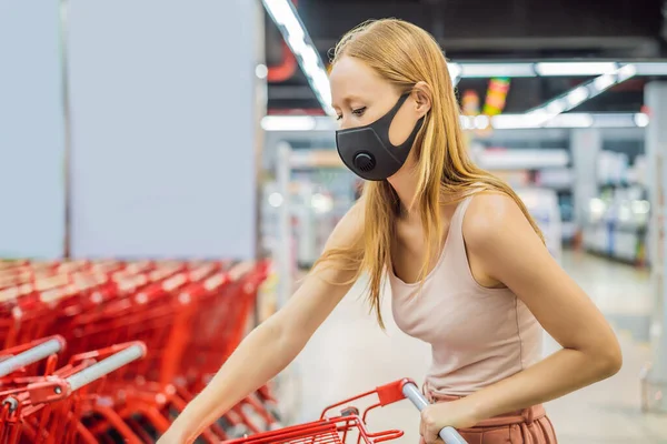 Тревожная женщина носит медицинскую маску против коронавируса во время покупок в супермаркете или магазине - здоровье, безопасность и пандемия - молодая женщина в защитной маске и запасах пищи — стоковое фото