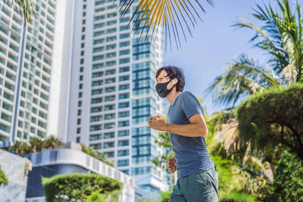 Man runner wearing medical mask. Running in the city against the backdrop of the city. Coronavirus pandemic Covid-19. Sport, Active life in quarantine surgical sterilizing face mask protection — Stock Photo, Image