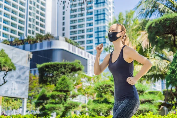 Woman runner wearing medical mask. Running in the city against the backdrop of the city. Coronavirus pandemic Covid-19. Sport, Active life in quarantine surgical sterilizing face mask protection — Stock Photo, Image