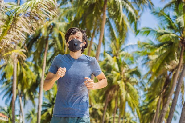 Man runner wearing medical mask. Running in the city against the backdrop of the city. Coronavirus pandemic Covid-19. Sport, Active life in quarantine surgical sterilizing face mask protection — Stock Photo, Image
