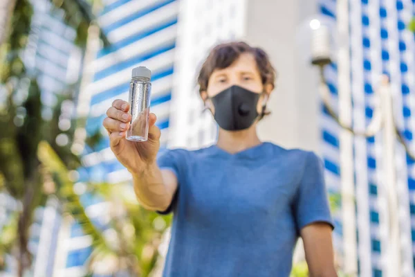 COVID-19 Coronavírus pandêmico, mãos de homem usando dispensador de gel desinfetante para mãos lavadas, contra o novo coronavírus 2019-nCoV ou o coronavírus Wuhan na rua da cidade. Antisséptico, Higiene e Cuidados de Saúde — Fotografia de Stock