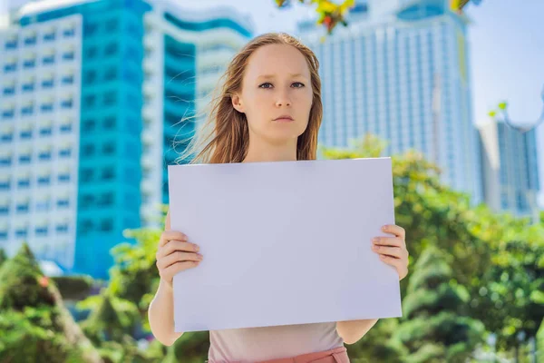 Mujer sostiene un cartel libre de inscripciones en la ciudad —  Fotos de Stock