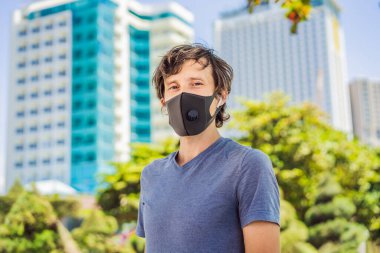 Şehirde filtresi olan modaya uygun siyah tıbbi maske. Coronavirus 2019-ncov salgını. Siyah tıbbi maskeli bir adam. Virüs ya da hastalık salgını sırasında etkileyici gözleri olan bir adamın portresi.