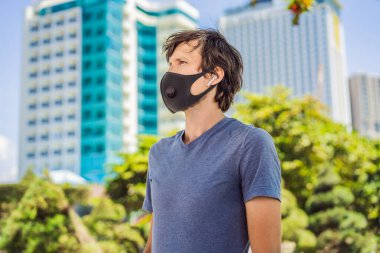 Şehirde filtresi olan modaya uygun siyah tıbbi maske. Coronavirus 2019-ncov salgını. Siyah tıbbi maskeli bir adam. Virüs ya da hastalık salgını sırasında etkileyici gözleri olan bir adamın portresi.