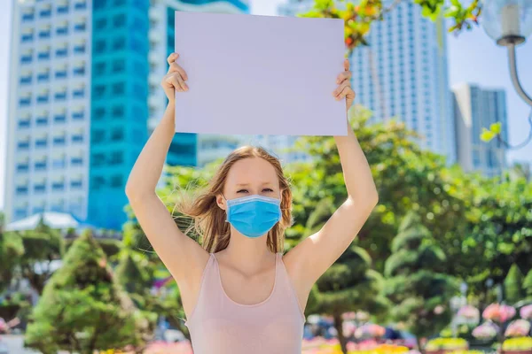 Nő orvosi maszkban megakadályozza a koronavírus betegség rendelkezik egy poszter ingyenes feliratok. COPY szóköz — Stock Fotó