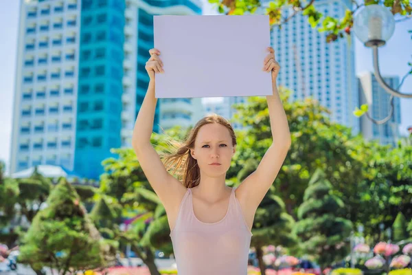 Mujer sostiene un cartel libre de inscripciones en la ciudad —  Fotos de Stock