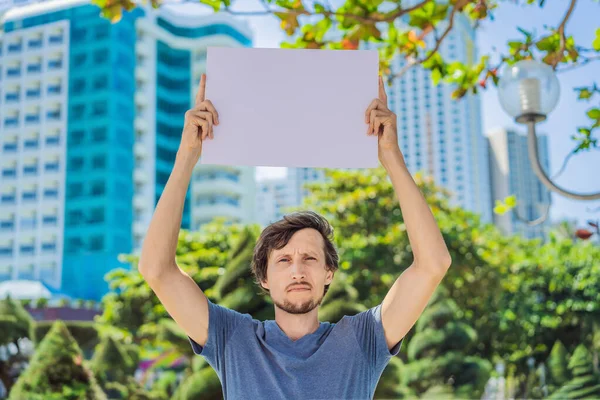 Hombre sostiene un cartel libre de inscripciones en la ciudad — Foto de Stock