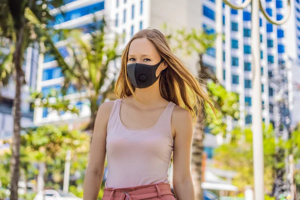 Μοντέρνα μαύρη ιατρική μάσκα με φίλτρο στην πόλη. Coronavirus 2019-ncov επιδημία έννοια. Γυναίκα με μαύρη ιατρική μάσκα. Πορτρέτο μιας γυναίκας με εκφραστικά μάτια κατά τη διάρκεια ενός ιού ή μιας ασθένειας — Φωτογραφία Αρχείου