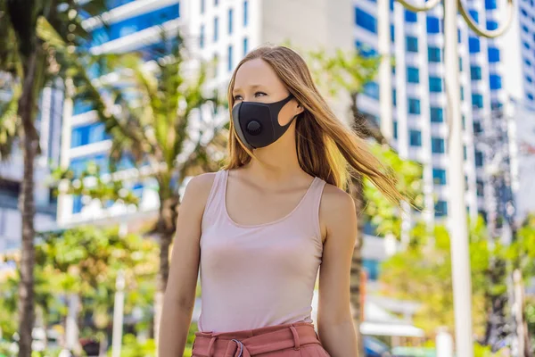 Fashionable black medical mask with filter in the city. Coronavirus 2019-ncov epidemic concept. Woman in a black medical mask. Portrait of a woman with expressive eyes during a virus or disease — Stock Photo, Image