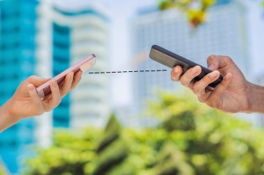 KOVID-19 pandemik Coronavirus Mobil Uygulaması. İnsanlar, 2019-20 Coronavirus 'a cevap vermek için City Street' te akıllı telefon uygulaması kullanarak yüz maskesi takıyor.