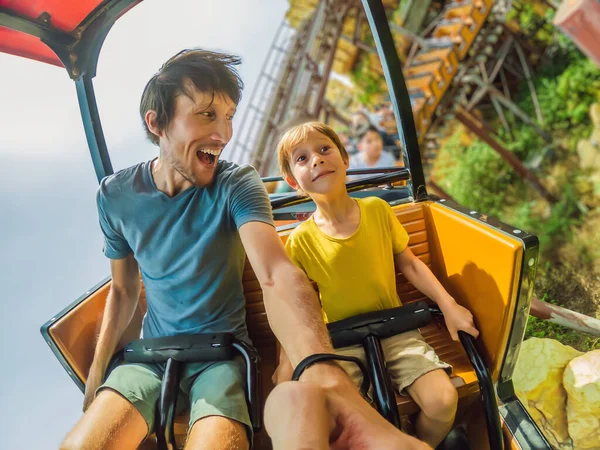 Père et fils s'amusent sur les montagnes russes — Photo