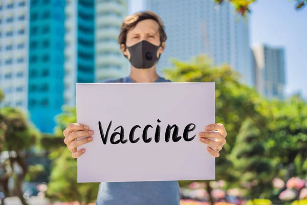 의료용 마스크를 쓴 사람 이 코로나 바이러스에 걸리지 않도록 예방하기 위해 백체 위에 글씨를 써서 손으로 쓴 백신을 보유하고 있다. 코로나 바이러스 COVID 19 개념 — 스톡 사진