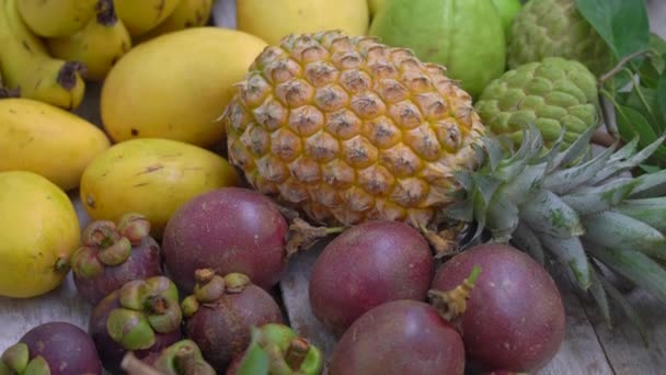 Багато тропічних фруктів на дерев'яному тлі — стокове відео