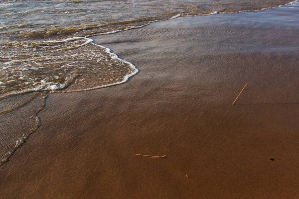 En bakgrund av en sandstrand med en vikande våg — Stockfoto