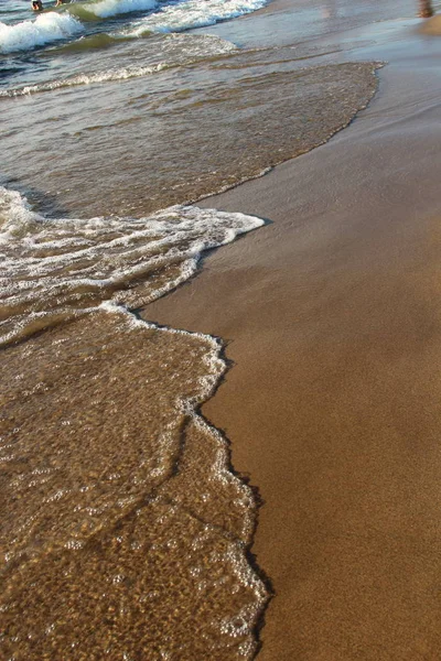 En bakgrund av en sandstrand med en vikande våg — Stockfoto