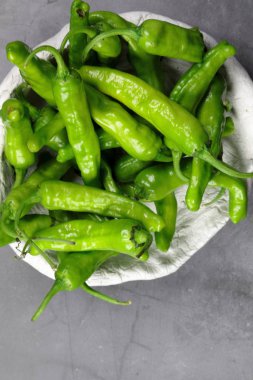 Bir kabın içinde yeşil Shishito biberleri