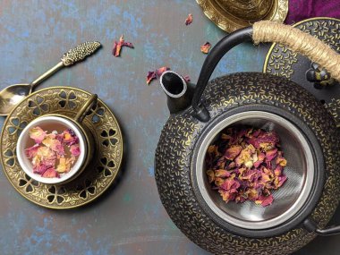 Metal çaydanlıklı bir fincan gül çayı..