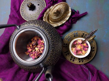 Metal çaydanlıklı bir fincan gül çayı..