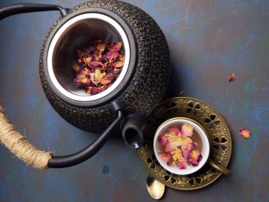Metal çaydanlıklı bir fincan gül çayı..
