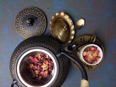 Metal çaydanlıklı bir fincan gül çayı..