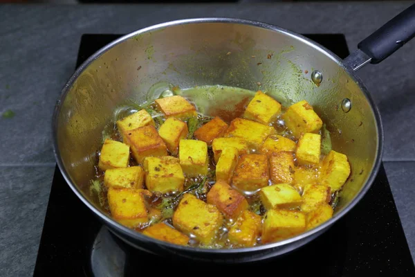 Cooking and frying Paneer or Tofu in oil with Turmeric and green — Stock Photo, Image