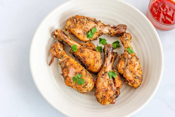 Beyaz bir zemin üzerinde domates ketçaplı fırında tavuk budu ve Cilantro, Top View Photo, Close-Up. Depo fotoğraflarına gönderilir
