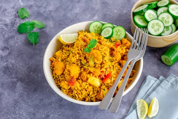 Karnabaharlı sebzeli pilav, salatalık dilimleri, limonata, acı biber ve nane yaprakları ile servis edilir.