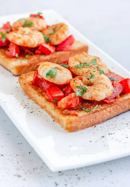Shrimp Toast on White Platter Top View Food Photo. Toast with Shrimp, Tomatoes, Parsley, Vertical High Angle Stock Photo