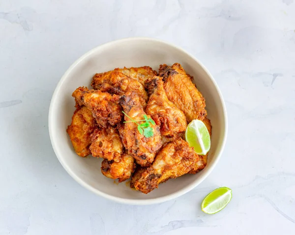 Bir kase soslu kızarmış tavuk kanadı ve limon en iyi manzaralı yemek fotoğrafı.
