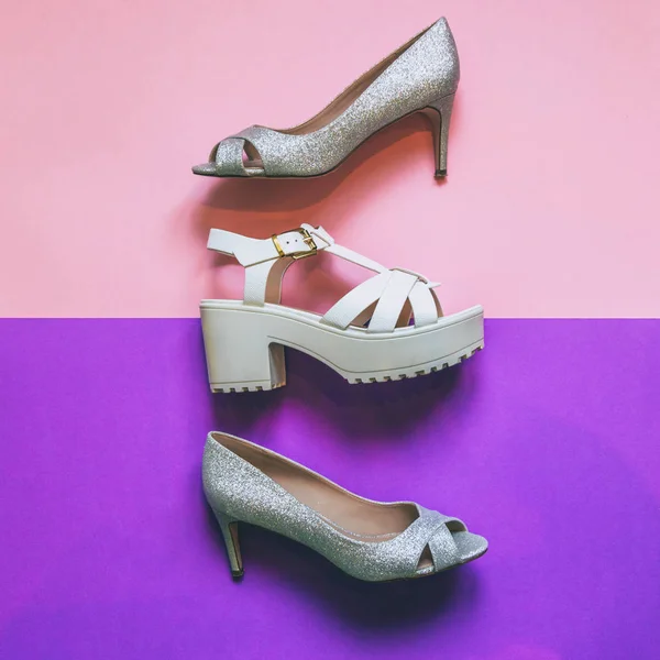 womens high hee silverl shoes and white sandals on pink and ultra violet background. fashion trend. minimal. flat lay