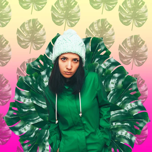 girl in green coat and hat on background of palm leaves