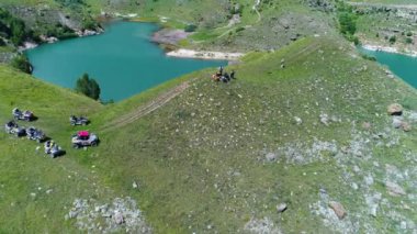 Turkuaz gölü Giggit ve bir grup turist at arabası ve Quad Biking 'de. Kuzey Kafkasya. Rusya