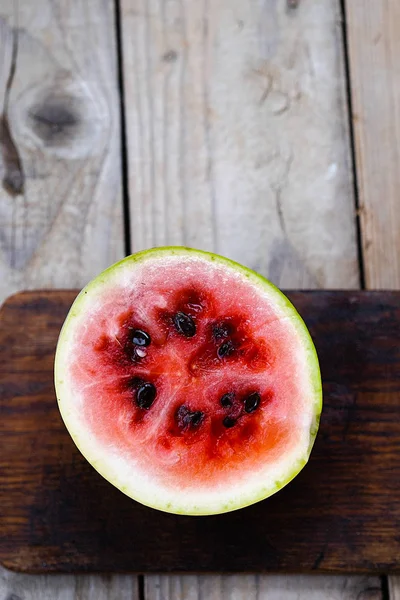 Ahşap bir arka plan üzerinde küçük karpuz kesmek