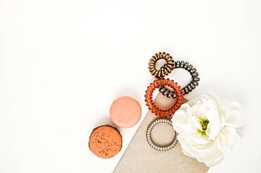 Kadınsı saç bantları, macarons ve beyaz bir çiçek düz lay 