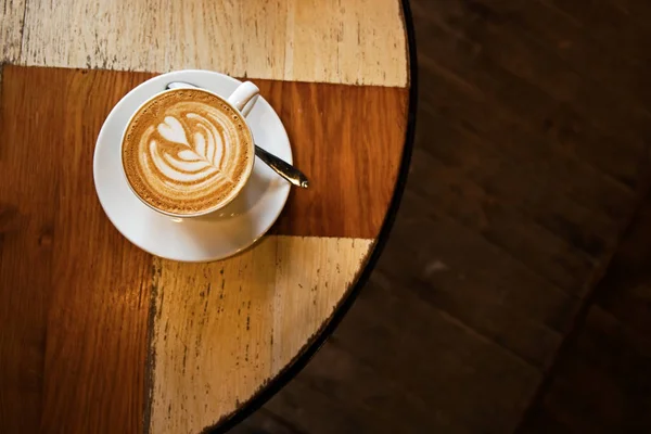 Xícara branca de cappuccino em uma mesa de madeira — Fotografia de Stock