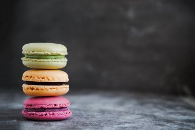 Karanlık bir taş zemin üzerine çeşitli renkli Fransızca macaroons 