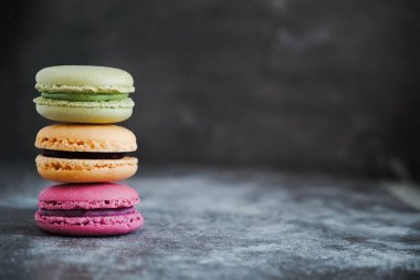 Karanlık bir taş zemin üzerine çeşitli renkli Fransızca macaroons 