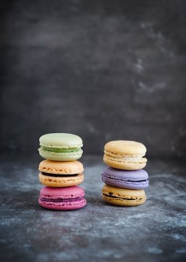 Karanlık bir taş zemin üzerine çeşitli renkli Fransızca macaroons 