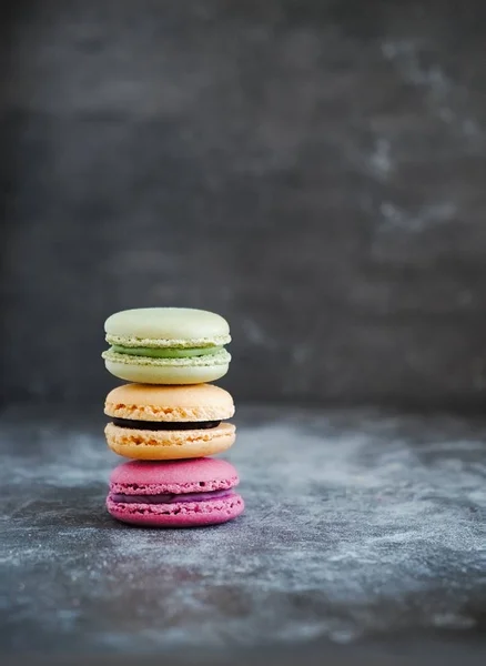 Macaroni francesi colorati assortiti su uno sfondo di pietra scura — Foto Stock