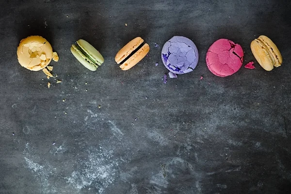 Karanlık bir taş zemin üzerine çeşitli renkli Fransızca macaroons 